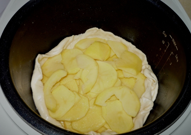 На тесто помещаем порезанный тонкими кружочками картофель